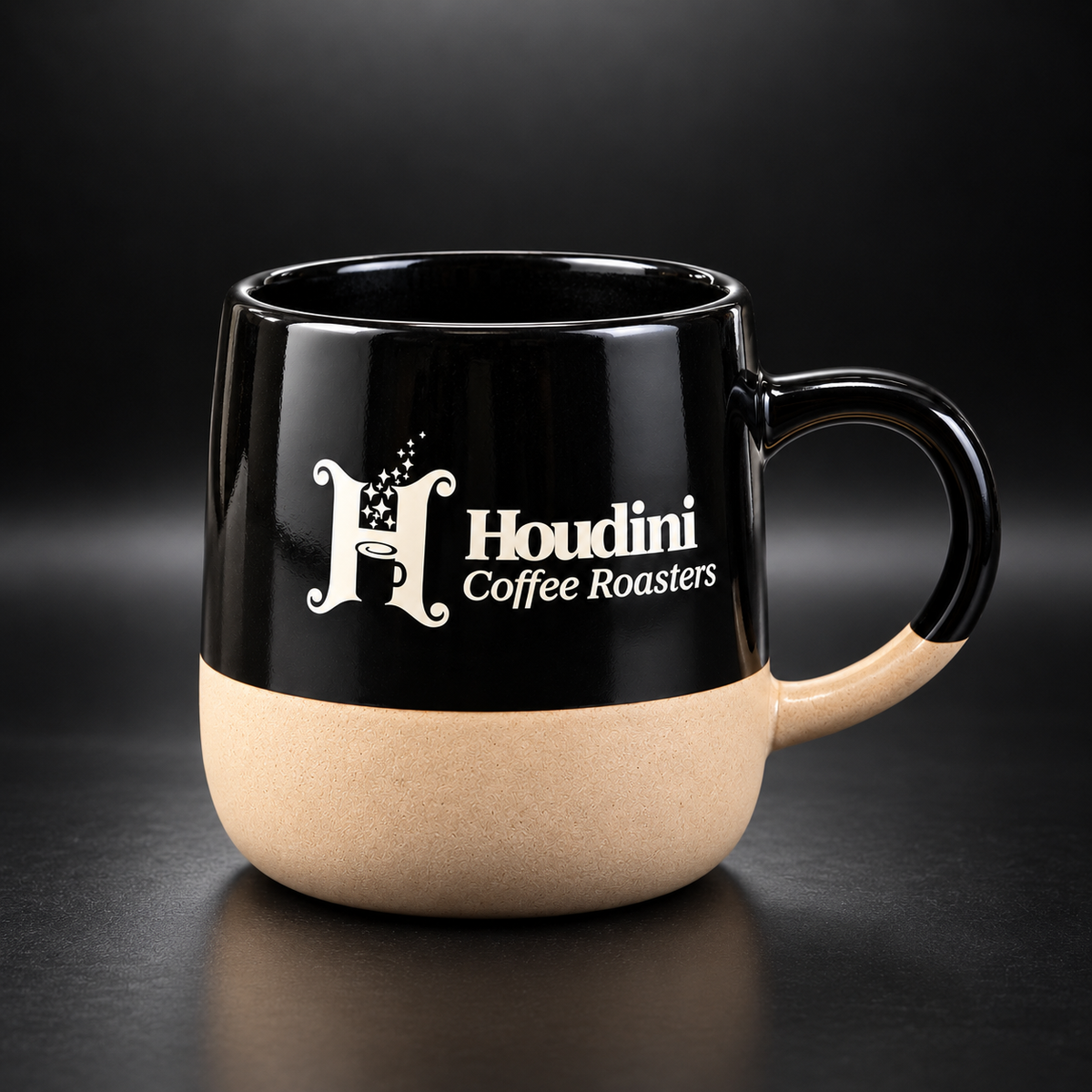 The Houdini Mug: a 12 oz ceramic mug with a glossy black top, natural clay base, and the off-white Houdini Coffee Roasters logo